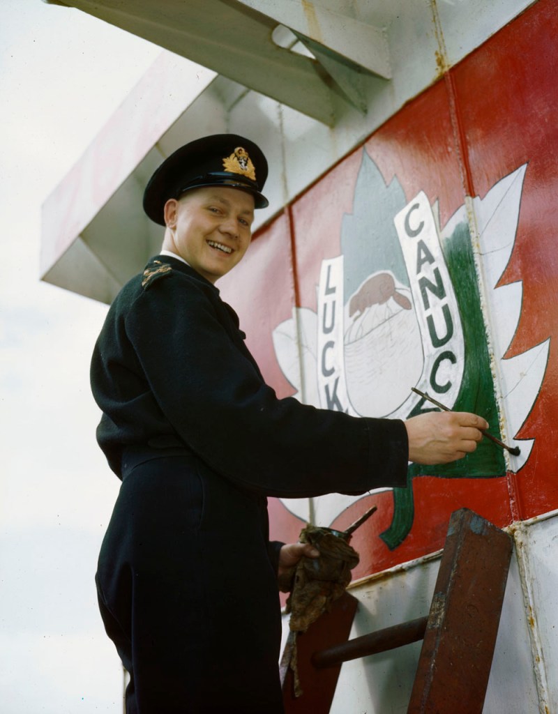 Sub-Lieutenant E.D. Rushbrook painting "Lucky Canuck" bridge art on the superstructure of LCI 118. (Library and Archives Canada, Item 4950840)